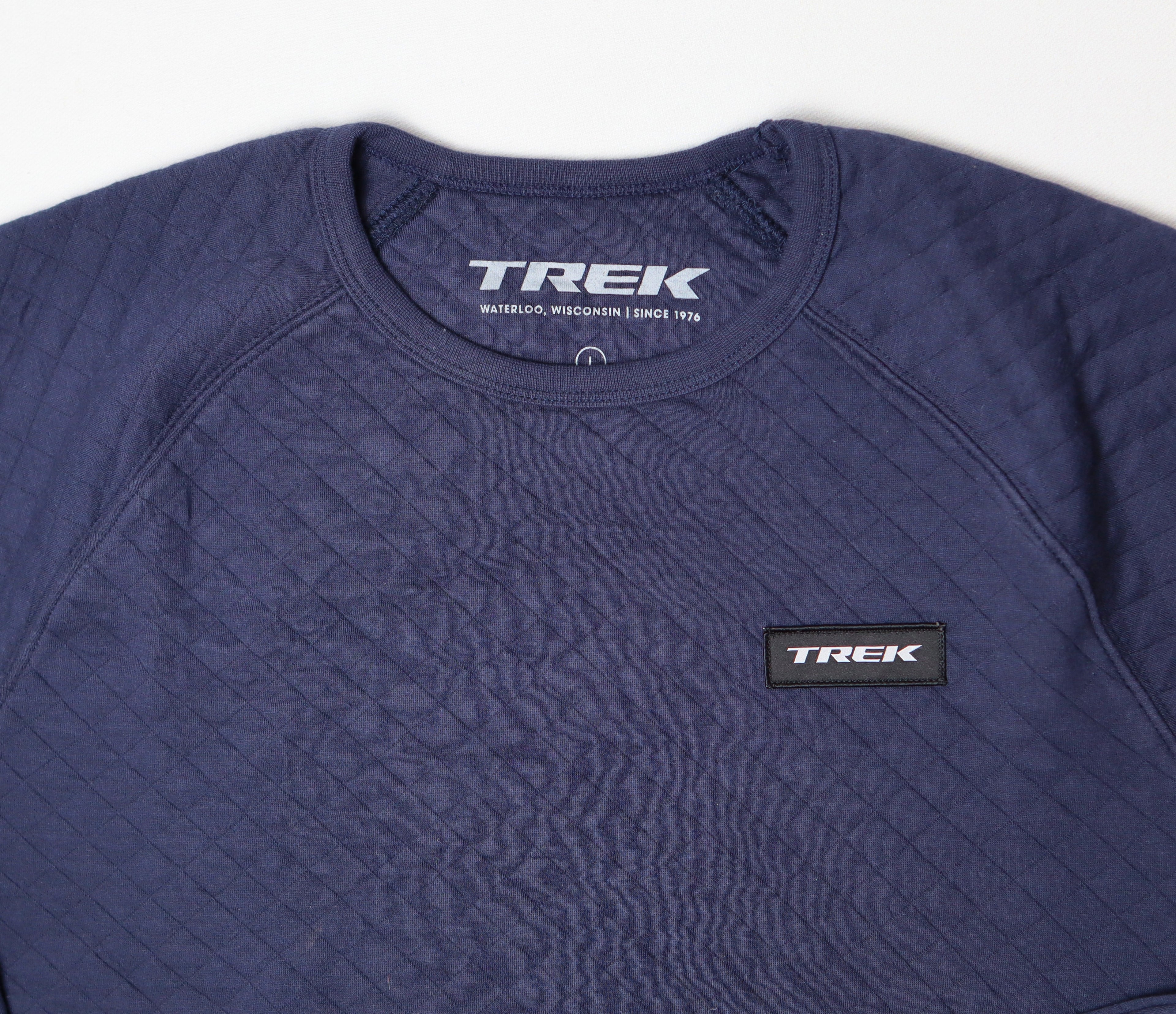 Trek logo en ronde hals van donkerblauwe sweater